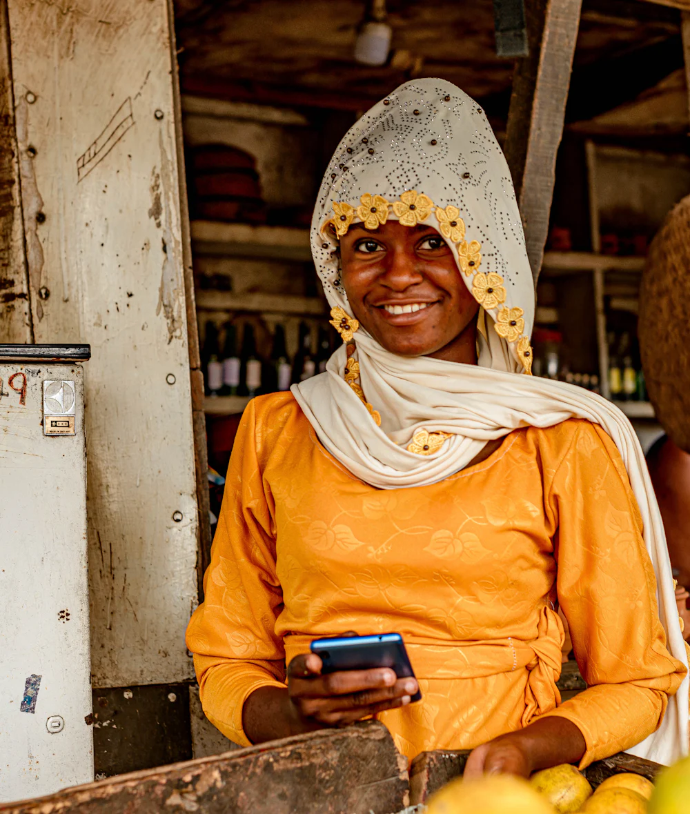 A market trader at her stall, checking her mobile phone
