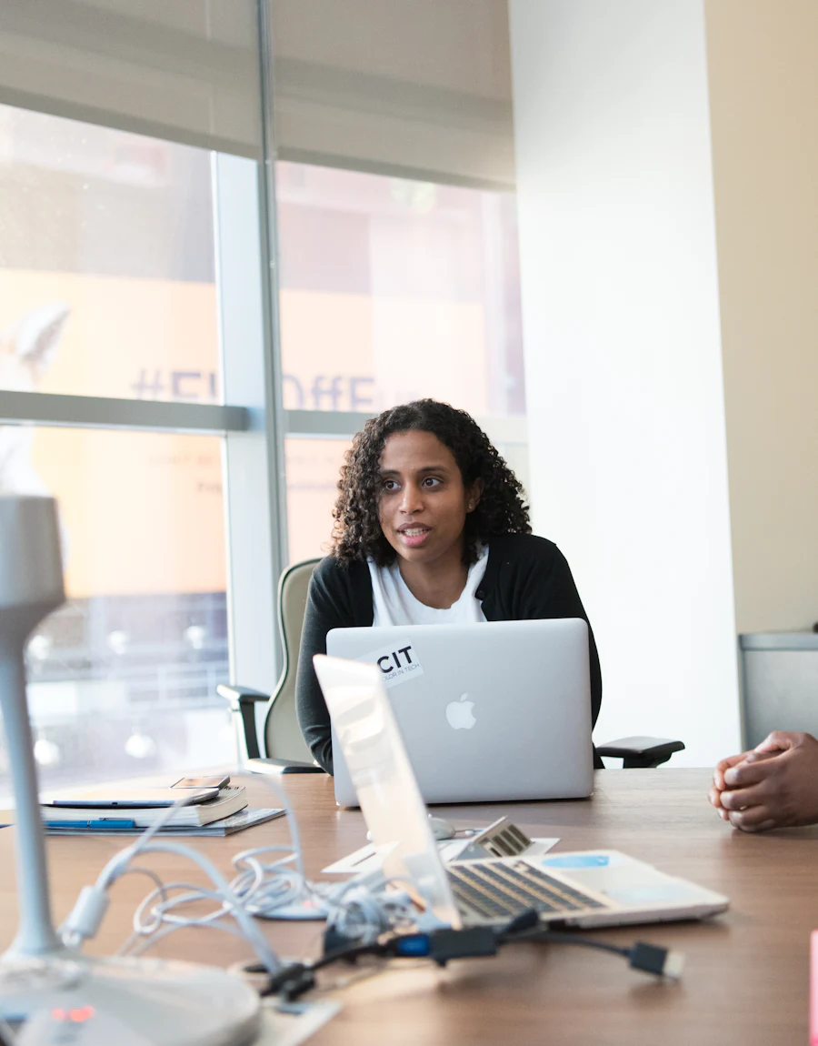 Three colleagues reviewing work together at an office desk