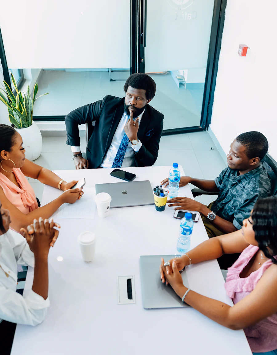 A team around a meeting table with laptops open